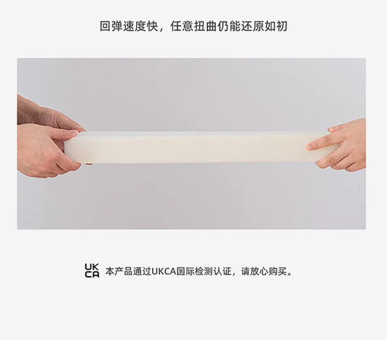 Hands holding a white, flexible, and resilient foam padding piece for an upholstered bed frame.
