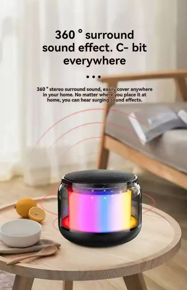 Small, black portable wireless speaker featuring a vibrant, multi-coloured LED light display on a wooden table.