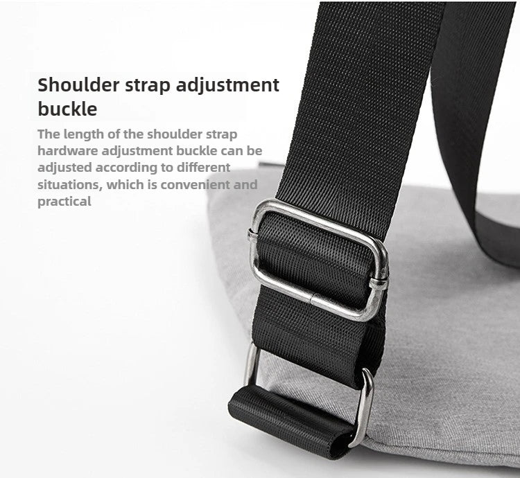 Close-up of a grey messenger bag showing a black adjustable strap with silver metal hardware.