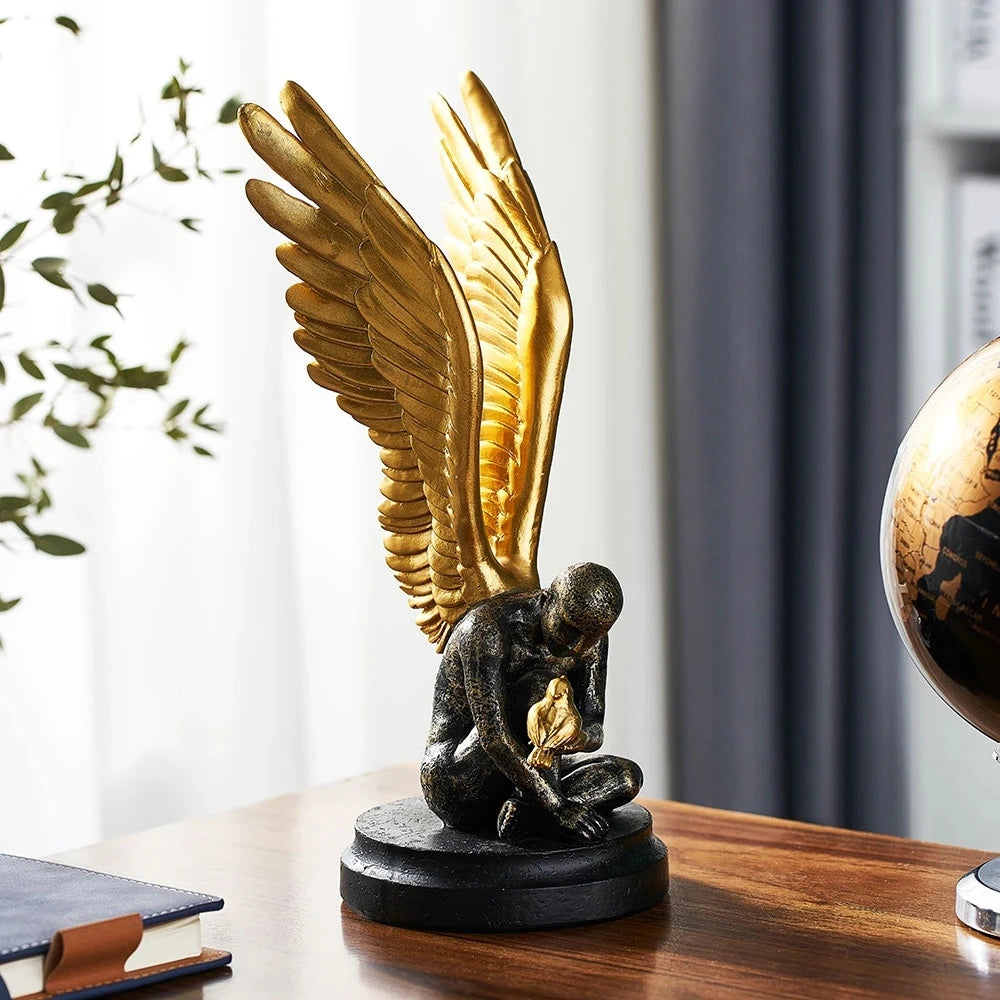 Elegant black and gold statue of a seated, winged figure holding a small bird, set on a circular base.