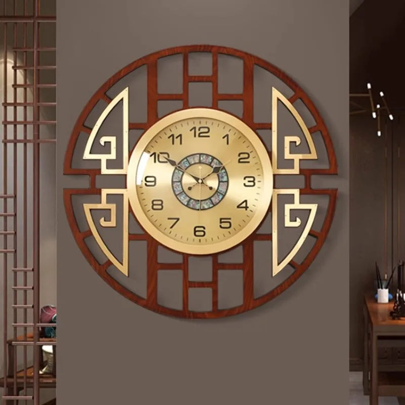 Round wall clock featuring a gold face with numerical markers, encased in a decorative dark wood-effect geometric frame.