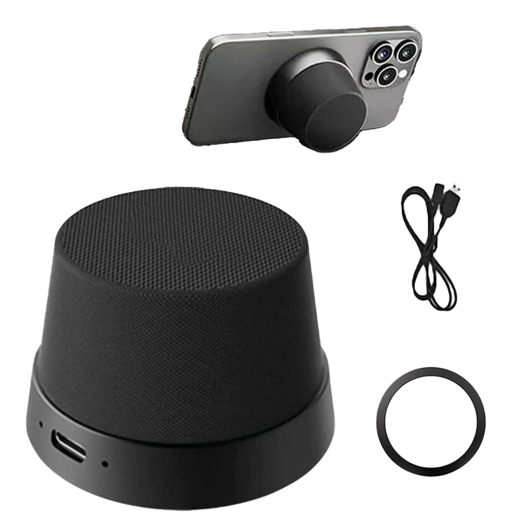 Black magnetic wireless speaker with charging cable and metal ring, shown attached to the back of a smartphone.