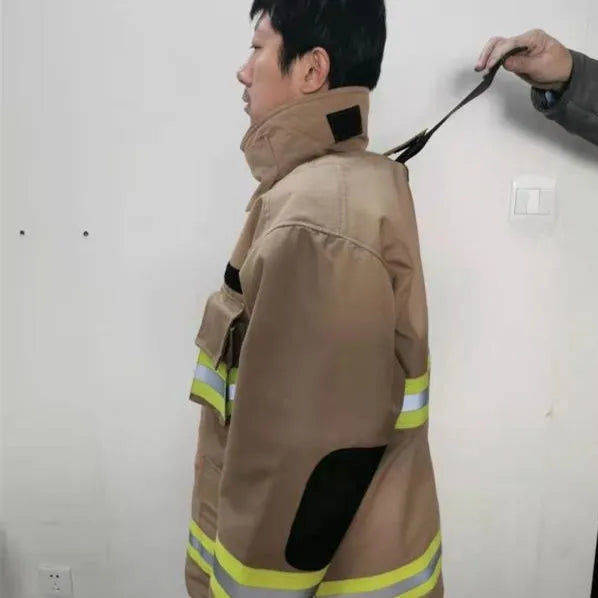 Tan-colored heavy-duty firefighter jacket with reflective yellow stripes, high collar, and reinforced elbow patches.