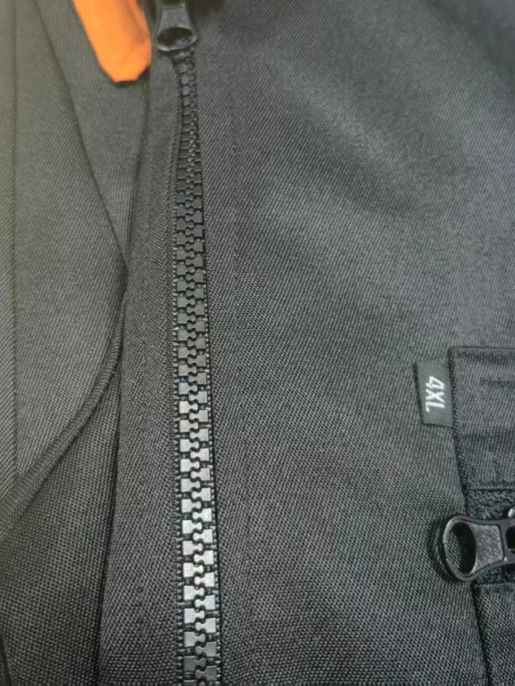 Close-up of durable, dark grey heavy-duty work coveralls featuring a sturdy front zip and a side pocket.