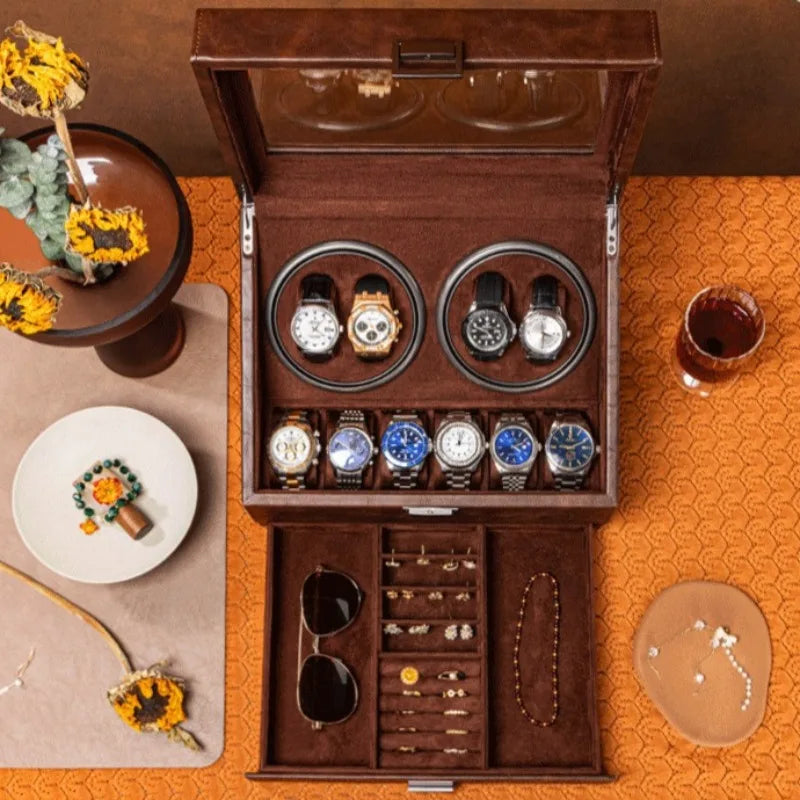 Brown leather watch winder box with glass lid, four automatic winders, six storage slots, and a jewelry drawer.