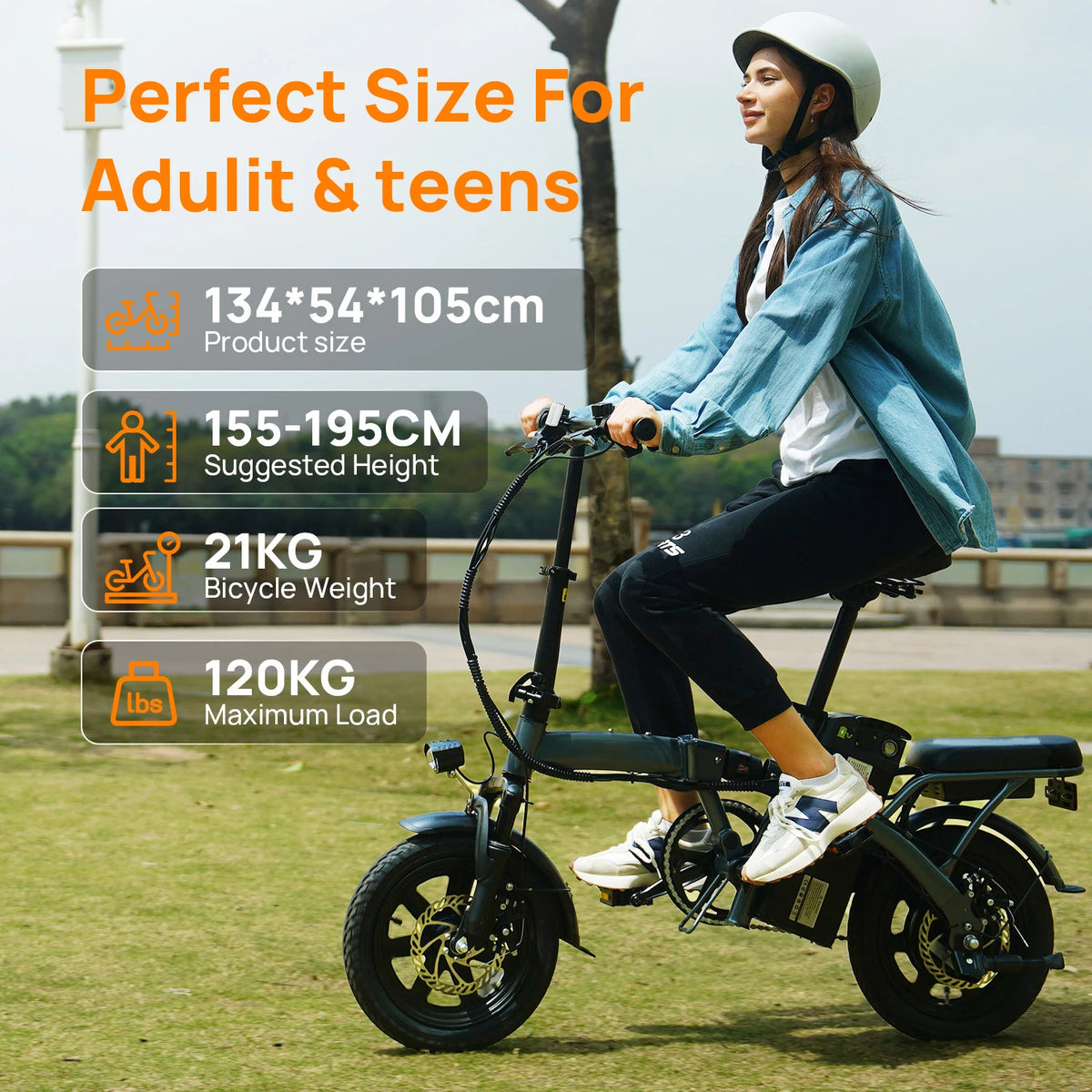 A person riding a dark grey foldable electric bike with small wheels, a rear rack, and disc brakes outdoors.