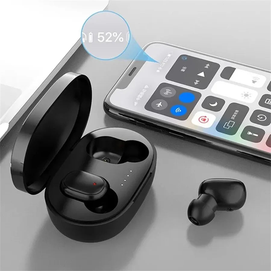 Black wireless earbuds in a charging case next to a smartphone showing a 52% battery status indicator.