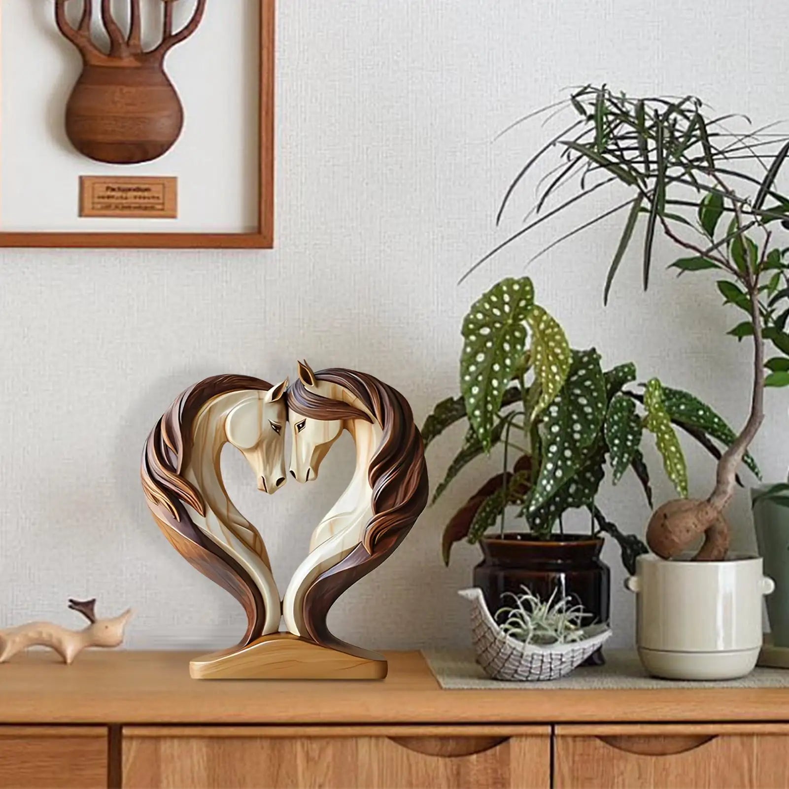 A decorative wooden-effect ornament featuring two horse heads facing each other, forming a heart shape.