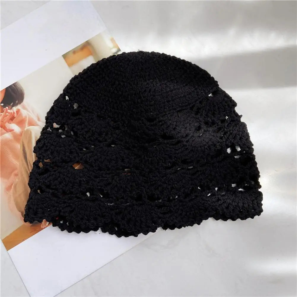 Black crochet beanie hat with a delicate, hollow-out scalloped pattern.