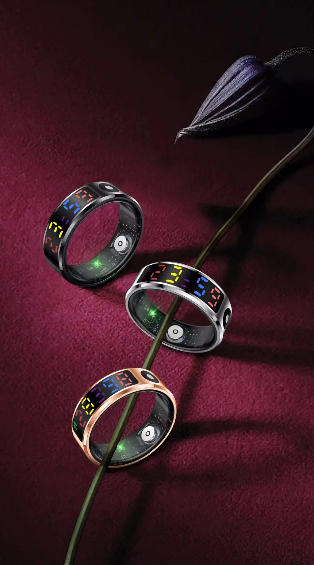 Three smart rings in black, silver and rose gold, featuring colourful touch displays and internal health sensors.