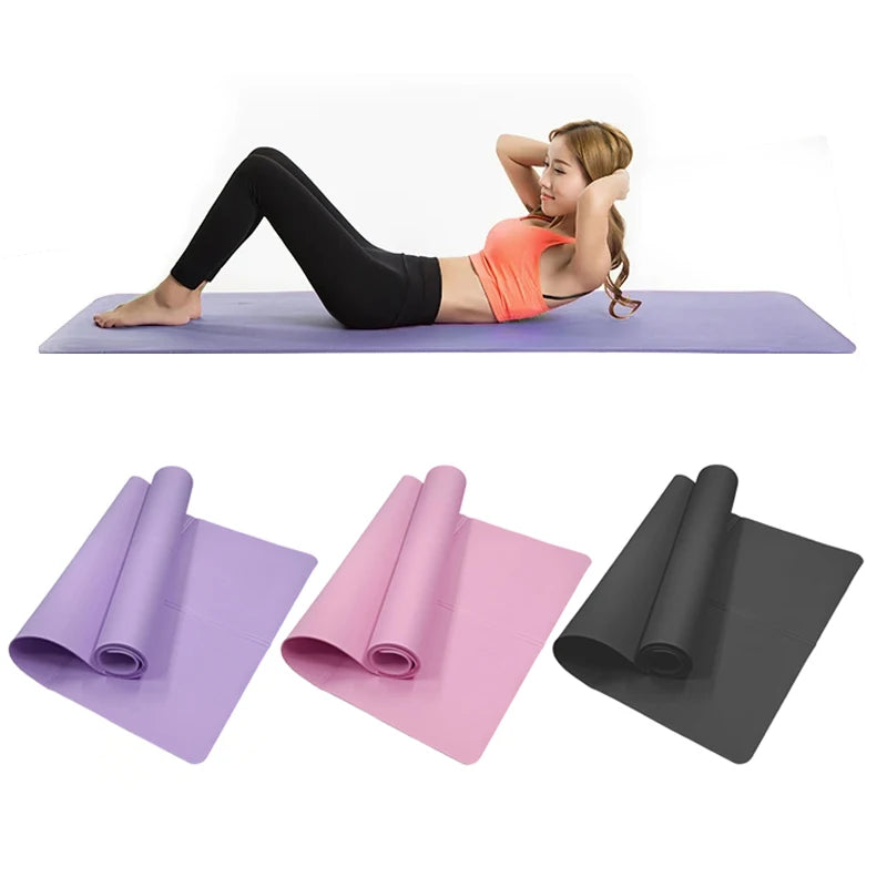 A woman doing sit-ups on a purple yoga mat, with additional rolled mats in purple, pink, and black below.