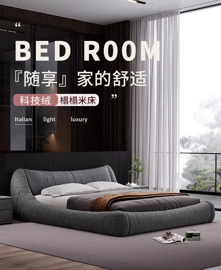 A low-profile, dark grey upholstered bed with a curved, textured headboard in a modern, luxury bedroom setting.