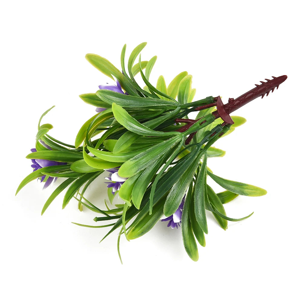 Artificial plastic flower sprig with vibrant green leaves and small purple blossoms on a dark, pointed stem.