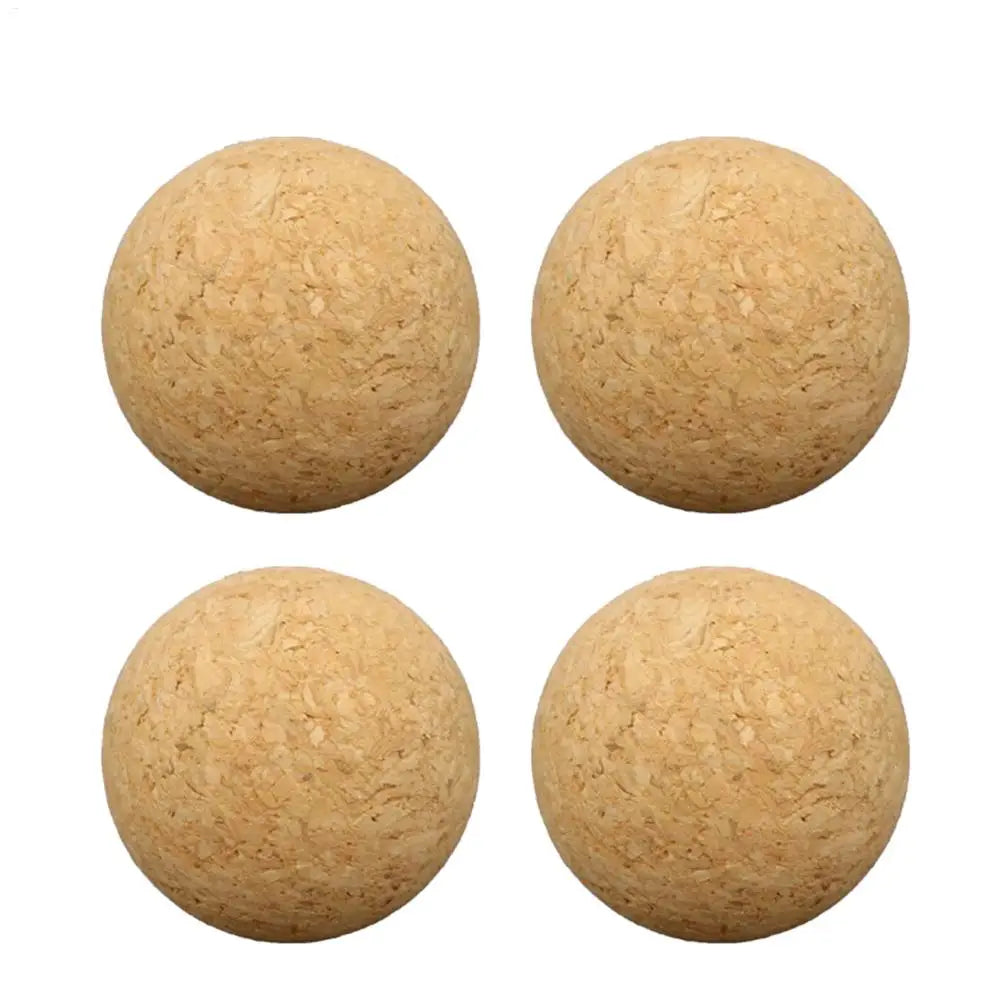 Four round, natural light brown cork balls with a textured, porous finish, isolated on a white background.