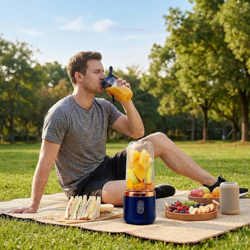 Man drinking from a portable dark blue and rose gold personal blender on a picnic blanket.