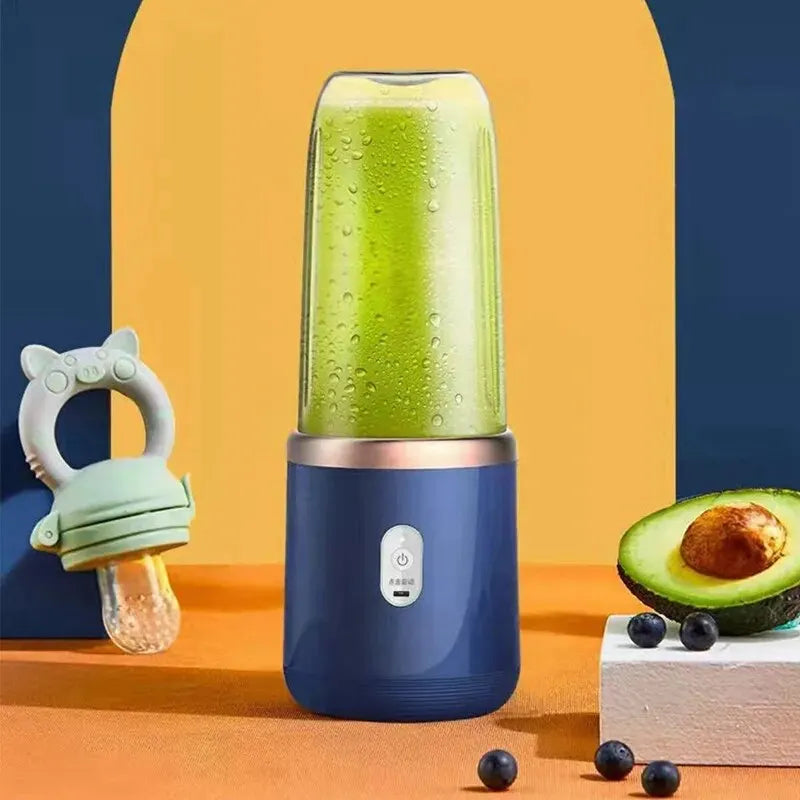 Portable blue blender filled with green smoothie, next to a baby feeder and halved avocado on a colorful background.