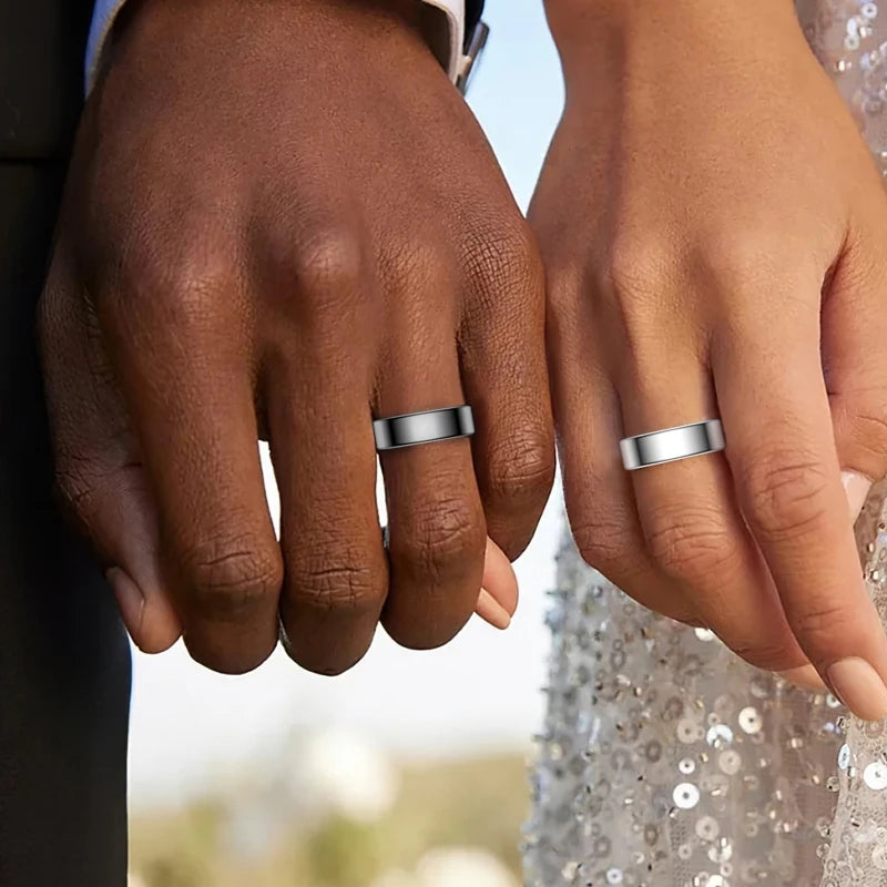 Two hands held together, each wearing a sleek, polished silver smart fitness tracking ring.