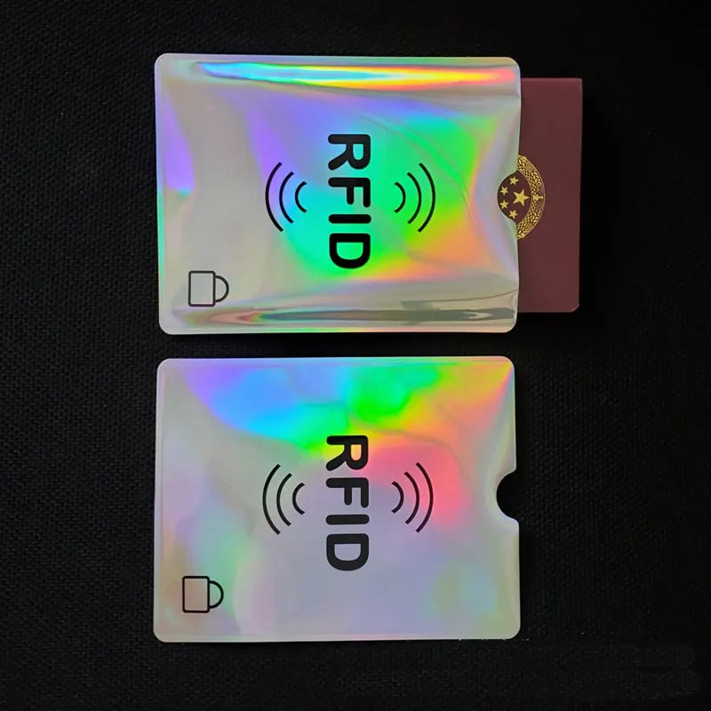 Two holographic metallic RFID-blocking sleeves for passports and credit cards on a black background.