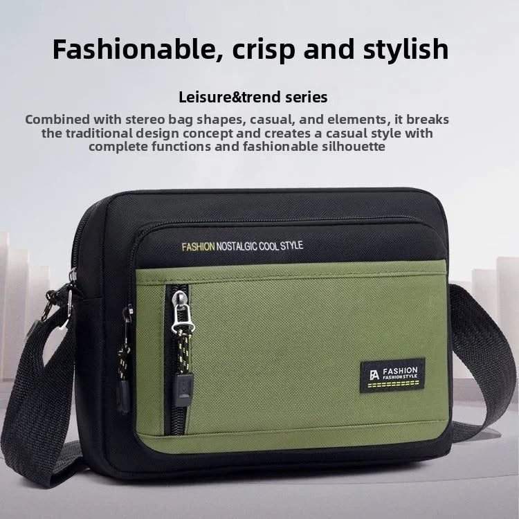 Black and olive green men's crossbody bag with a structured shape, zip compartments, and an adjustable shoulder strap.
