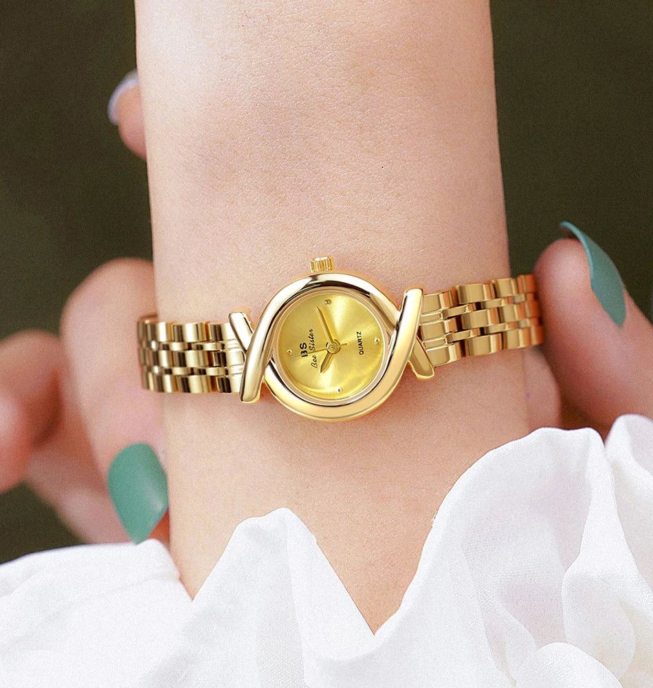 Elegant gold-toned women's quartz wristwatch with a delicate linked bracelet and unique criss-cross bezel design.