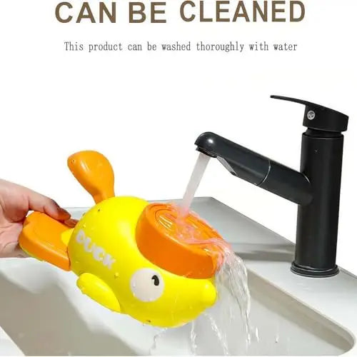 Yellow and orange duck-shaped toy being rinsed under a kitchen faucet, demonstrating the toy is washable.