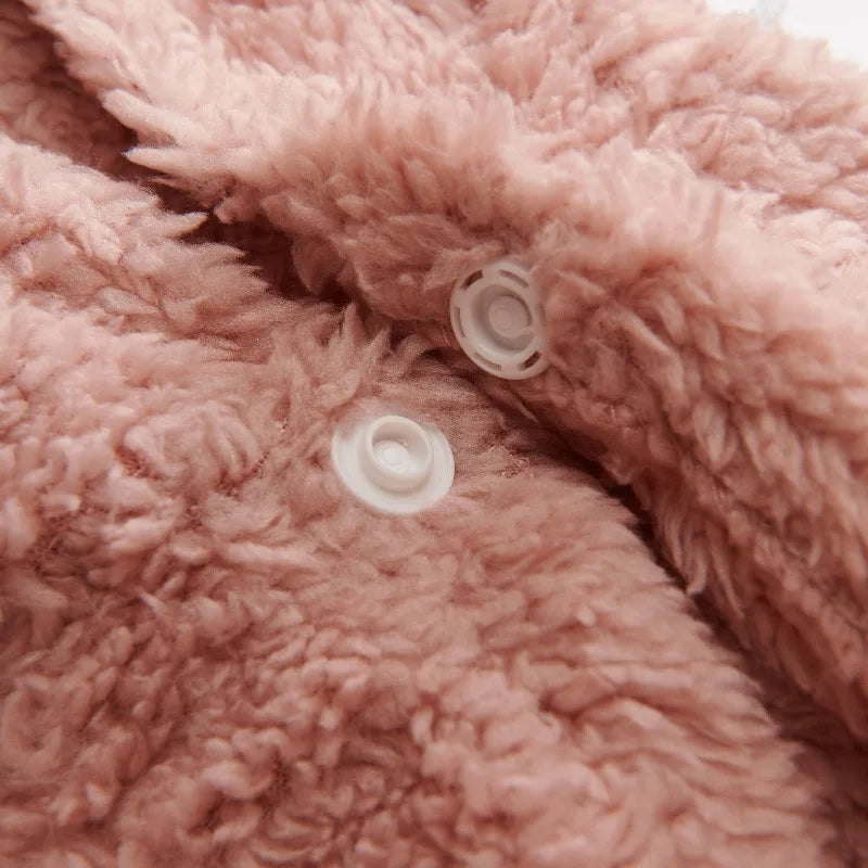 Soft pink fleece dog hoodie fabric detail with two white snap buttons.