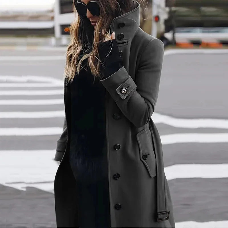 Woman wearing a charcoal grey button-up wool-blend trench coat with a high collar and cuffed sleeves.