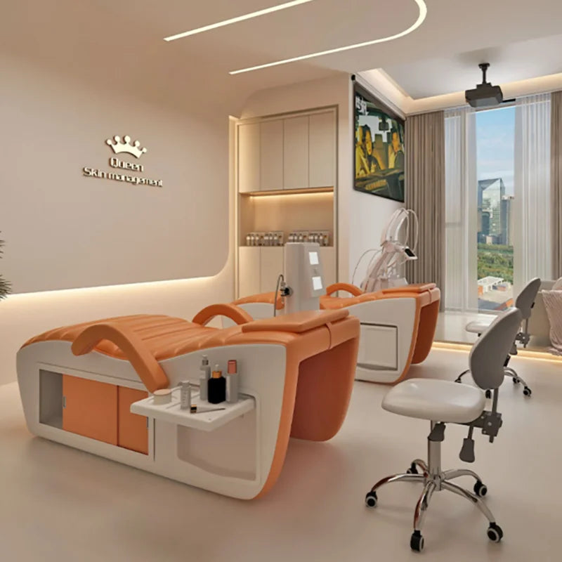 Modern orange and white professional massage bed featuring a sleek design with built-in side storage and shelf.