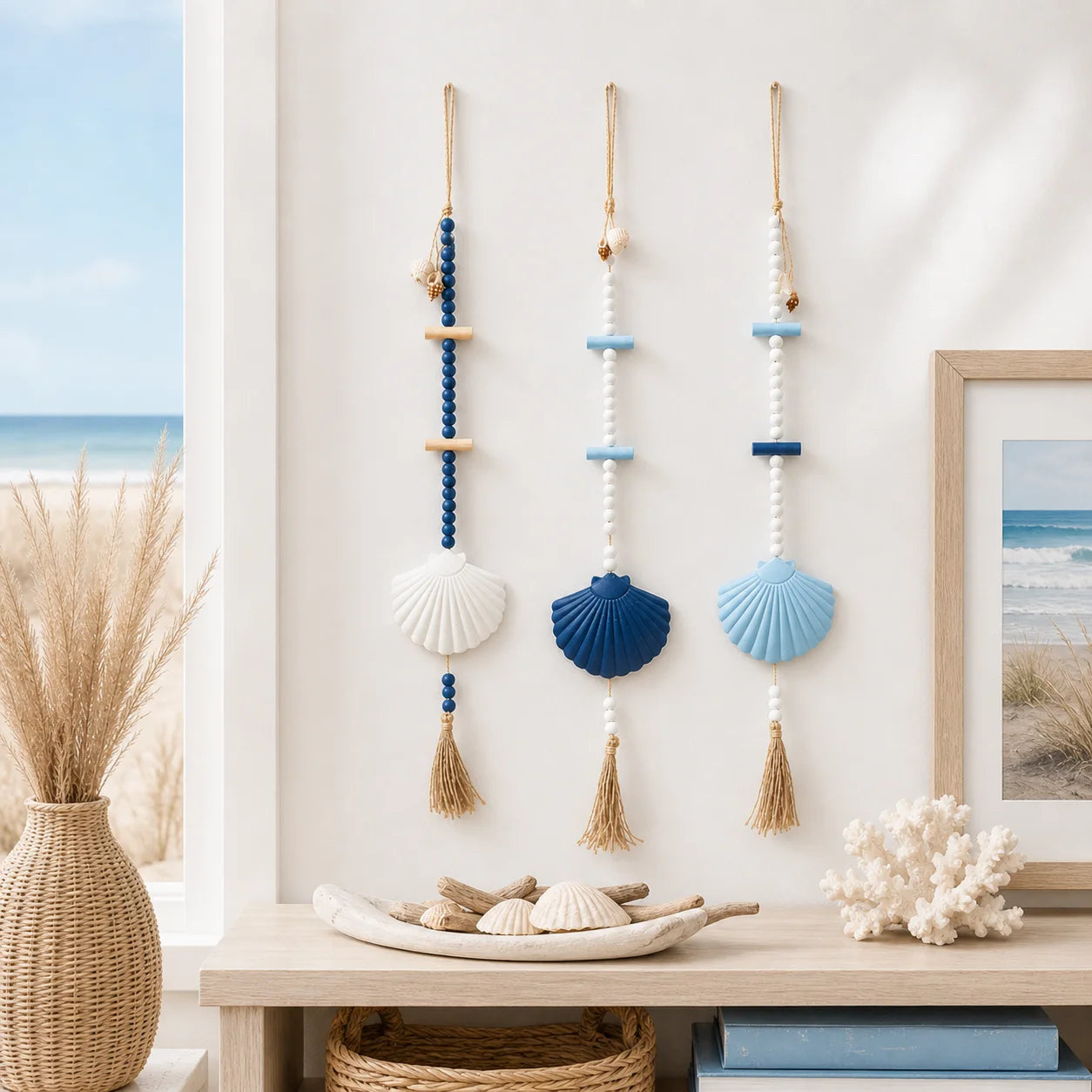 Three boho-style wall hangings featuring blue and white beads, large seashell accents, and natural jute tassels.