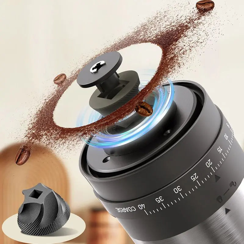 Manual coffee grinder with adjustable grind settings, featuring a metal body, conical burrs, and coffee grounds flying.