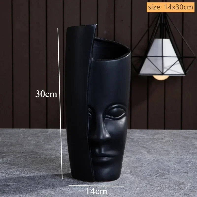 Matte black ceramic vase, 30cm tall, featuring a sculpted abstract human face design with a modern, artistic aesthetic.
