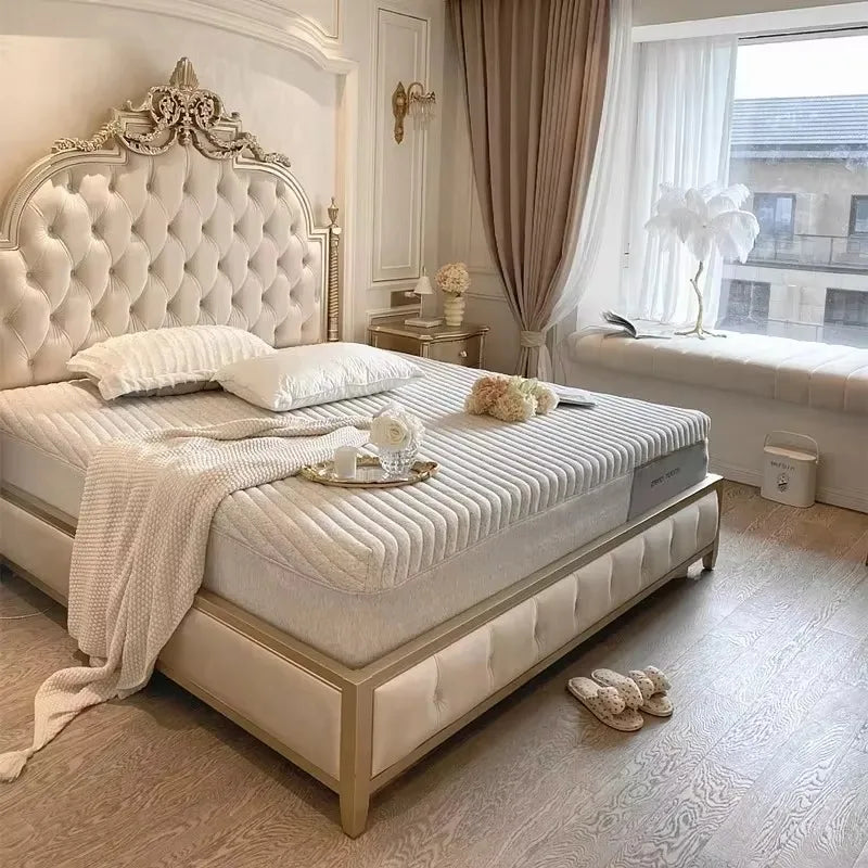 Cream Italian-style double bed frame with a tufted headboard, ornate gold detailing, and matching padded bed base.