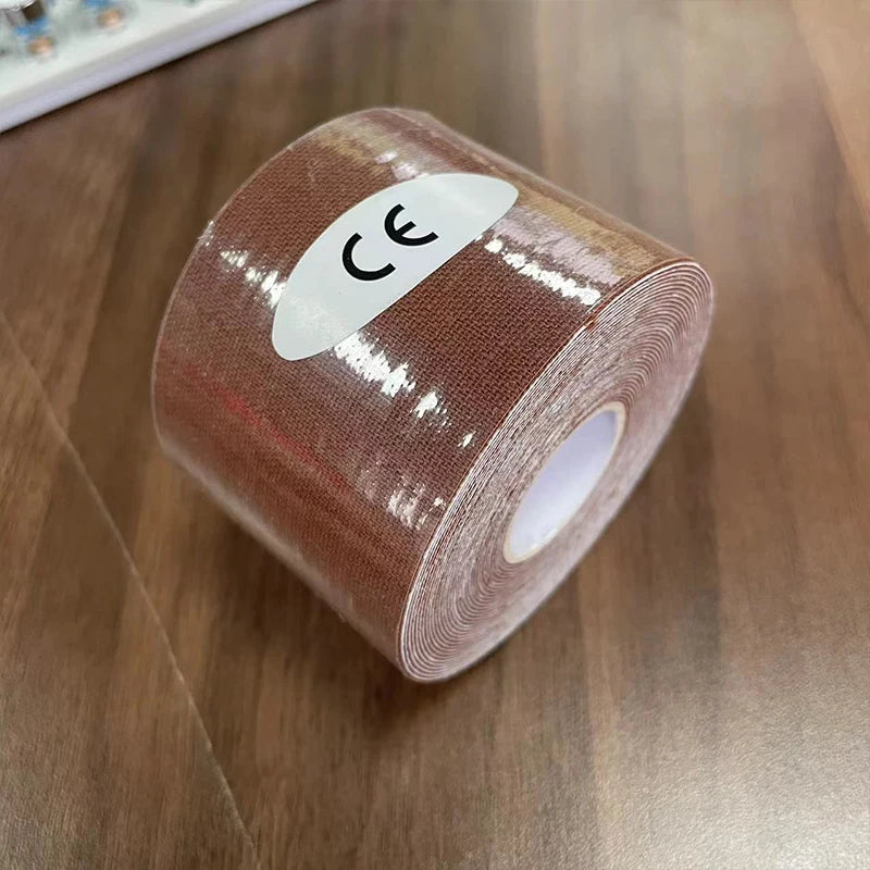 A roll of brown kinesiology tape with a white CE sticker, shown on a wooden surface.