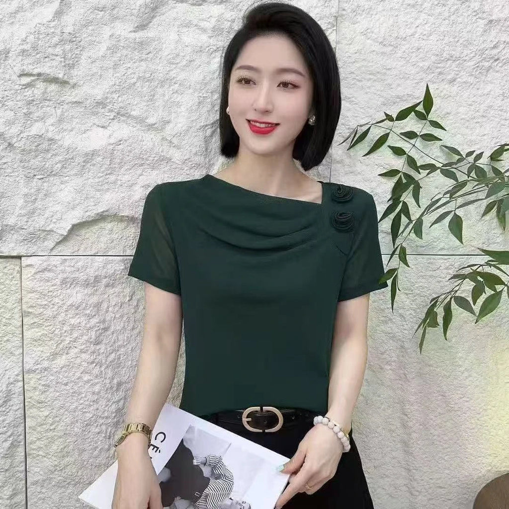 Dark green short-sleeved blouse with an asymmetrical neckline, draped detailing, and decorative floral accents.