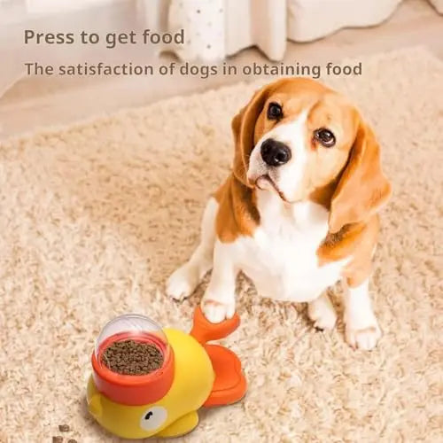A yellow and orange fish-shaped interactive dog food dispenser on a rug with a beagle waiting nearby.