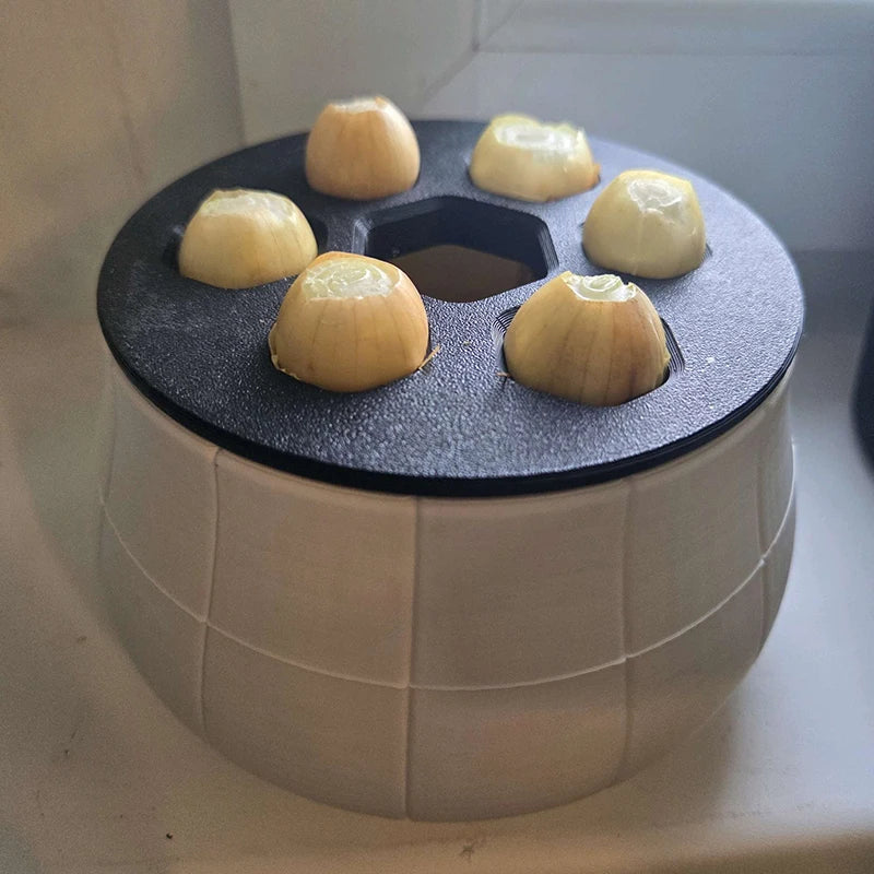 A beige, tiled-pattern 3D-printed pot with a black top containing five holes, each holding a yellow onion bulb segment.
