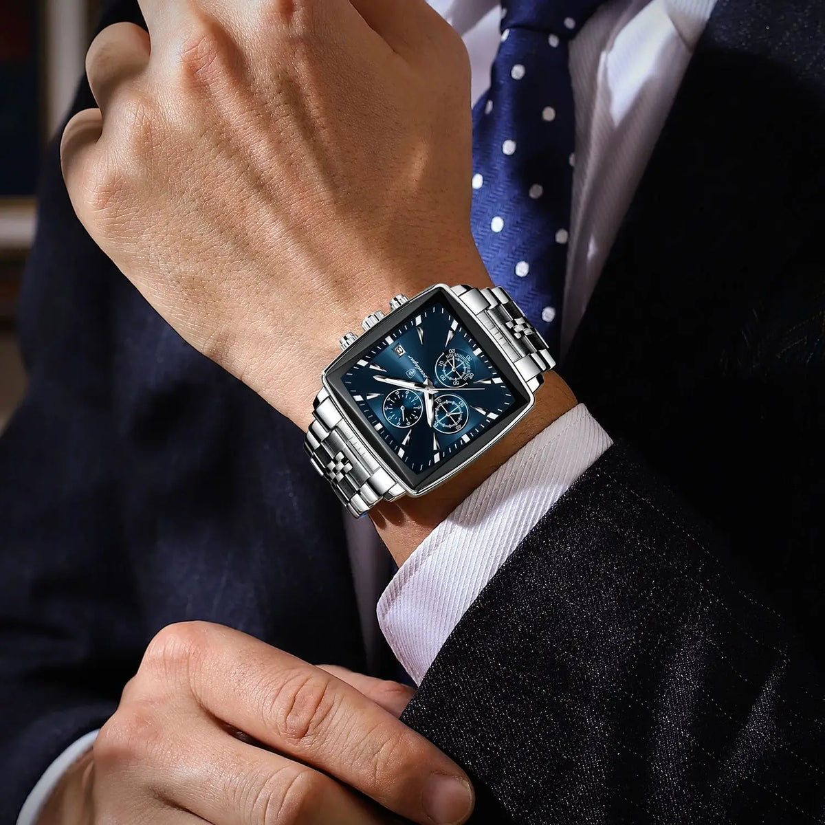 Silver men's square quartz watch with blue dial, chronograph subdials, and stainless steel link bracelet.