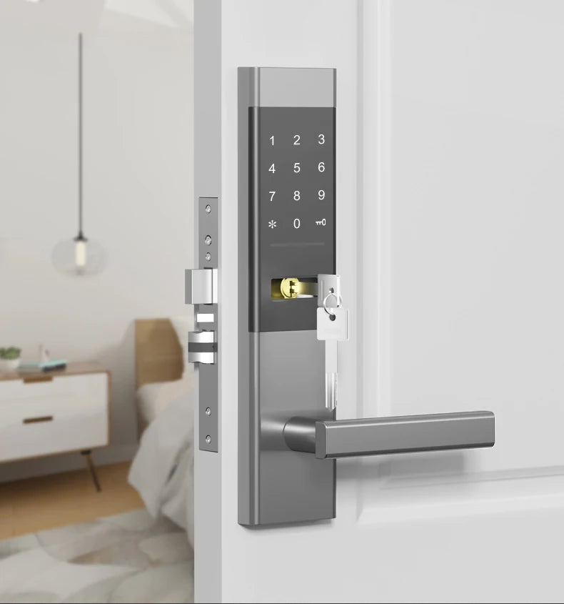 Grey metal digital door lock with keypad and physical key override installed on a white door.