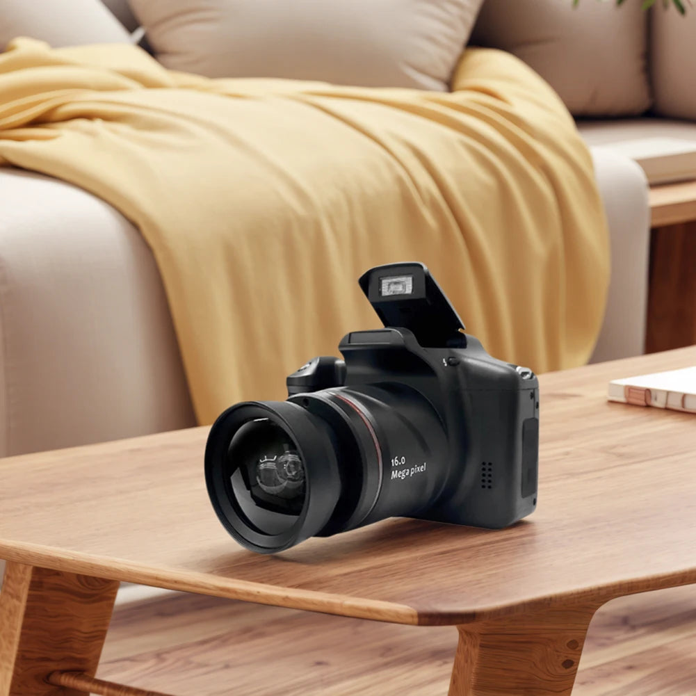 Black plastic digital SLR camera with a lens and pop-up flash, sitting on a wooden table.