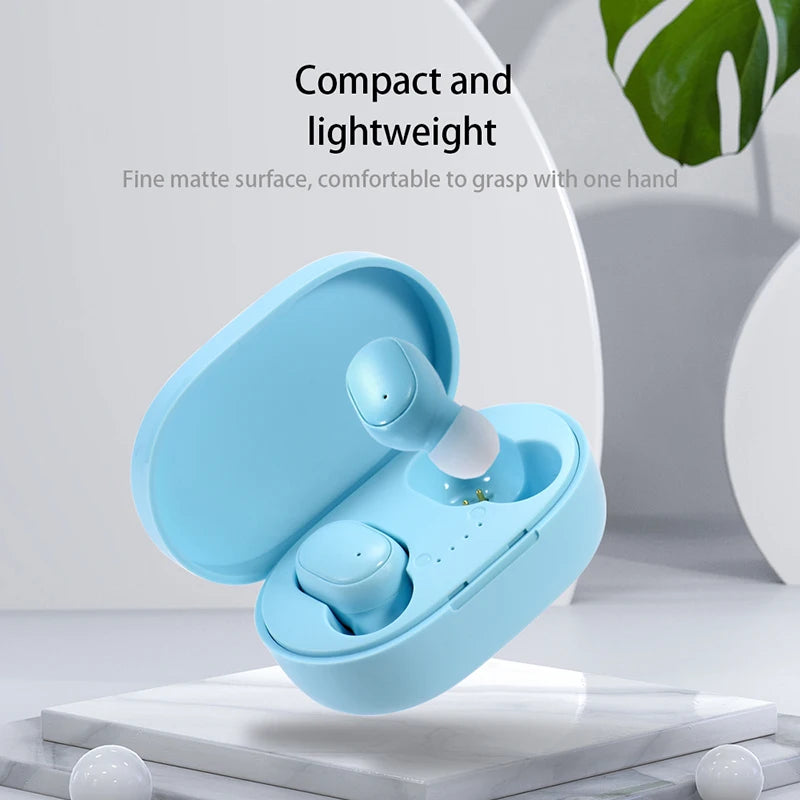 Compact light-blue wireless earbuds in a matching matte charging case, displayed on a white marble platform.