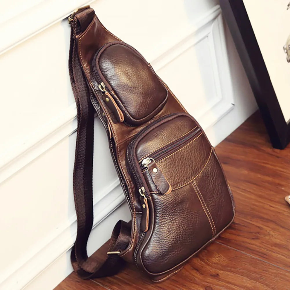 Dark brown, textured leather crossbody sling bag with multiple zip pockets and an adjustable shoulder strap.