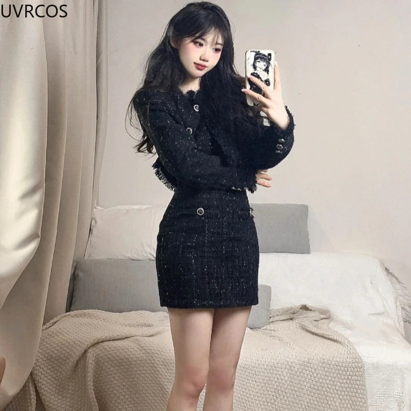 Black tweed two-piece set featuring a cropped jacket with fringe trim and a matching mini skirt.