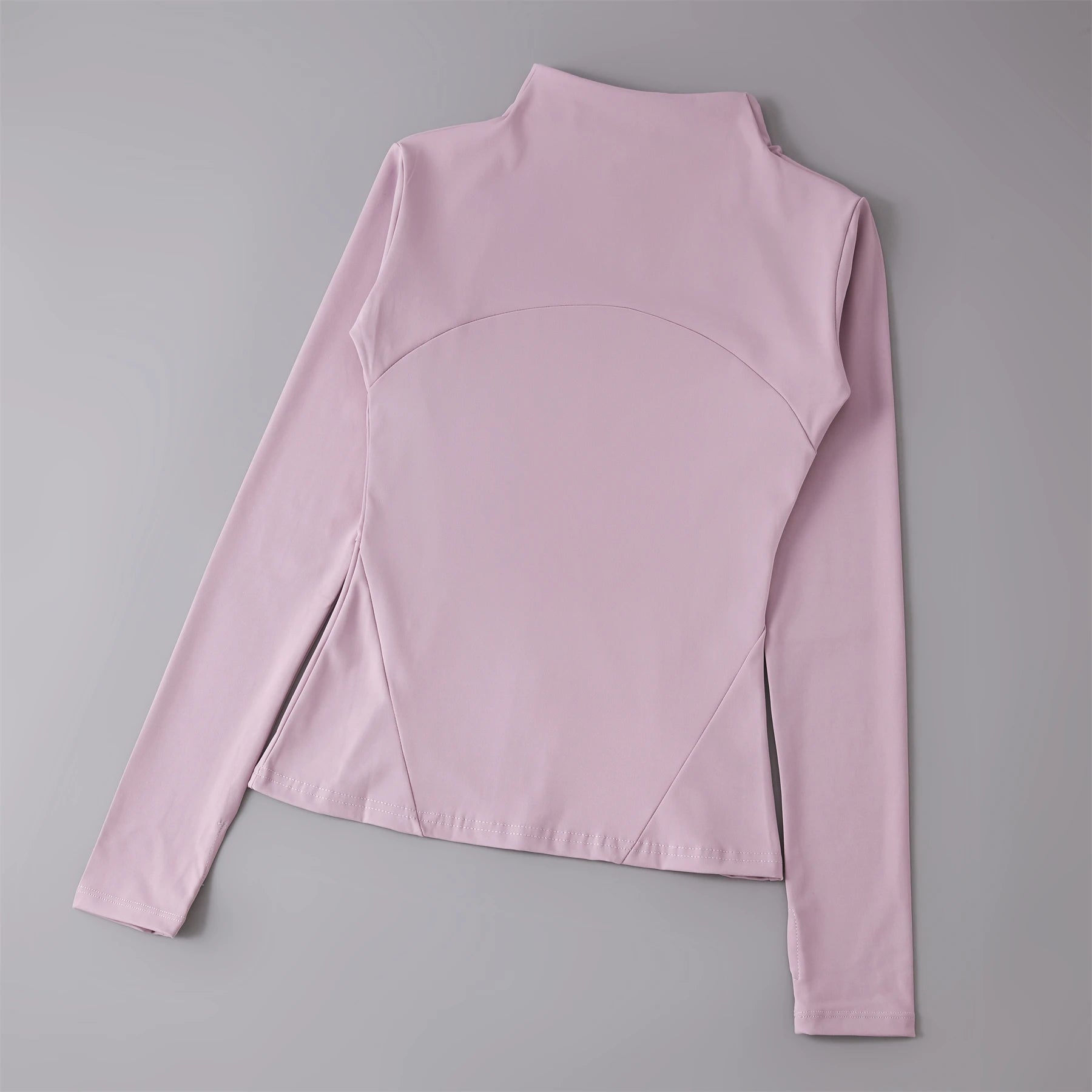 Dusty pink long-sleeve athletic top with a mock neck, curved chest panel, and fitted silhouette.