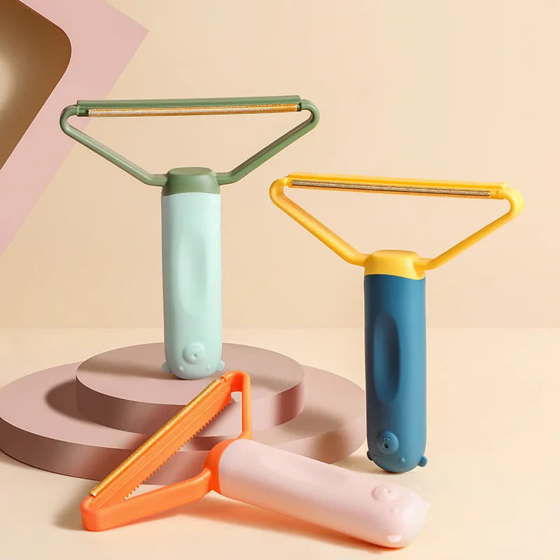 Three handheld fabric lint removers in sage green, yellow-blue, and orange-pink with cute bear-shaped base details.