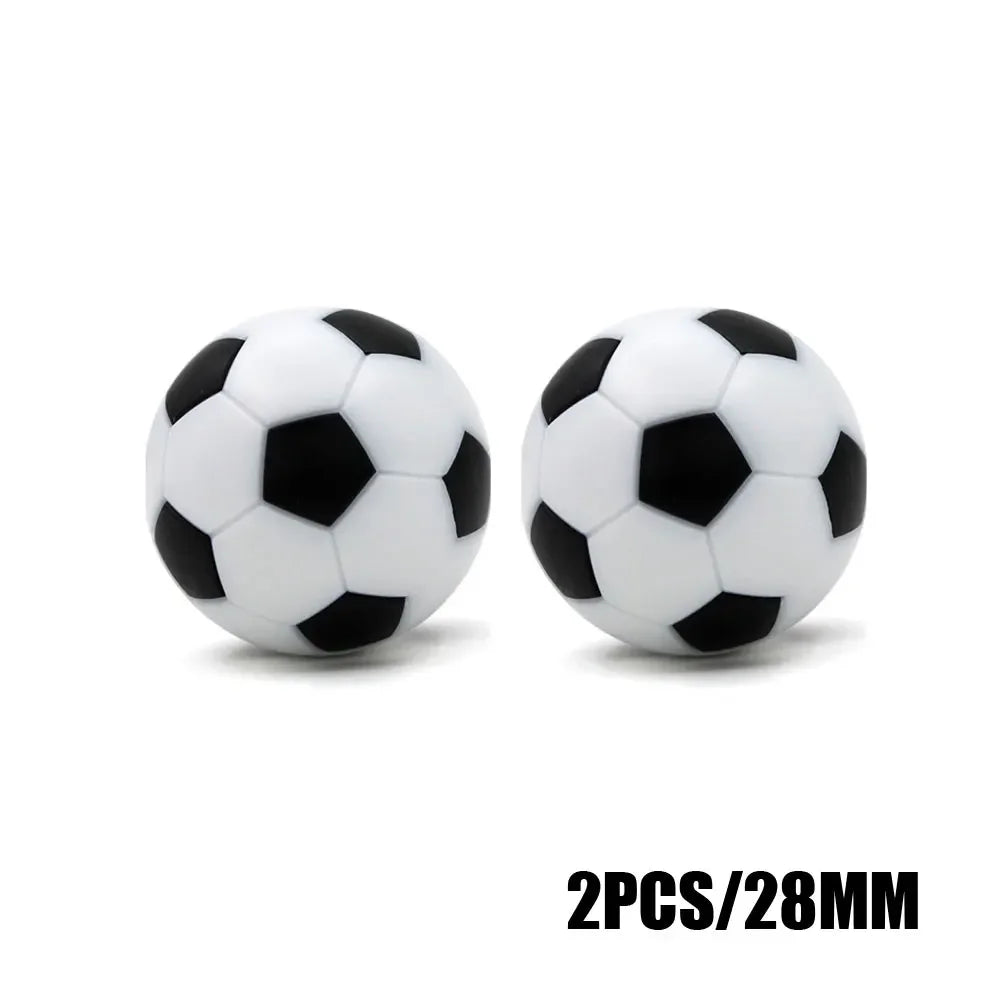 Set of two 28mm black and white football-style round beads or ornaments.