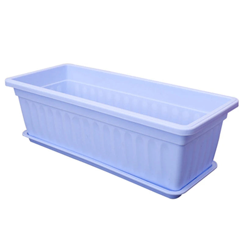 A light blue rectangular plastic planter box with vertical ribbed detailing and a matching drainage saucer.