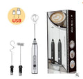 Silver USB-rechargeable handheld milk frother with three interchangeable whisk attachments and its retail packaging.