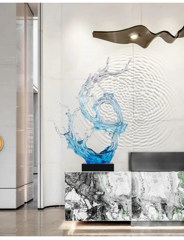 Modern artistic ornament featuring a blue resin sculpture resembling a dynamic water splash on a black square base.