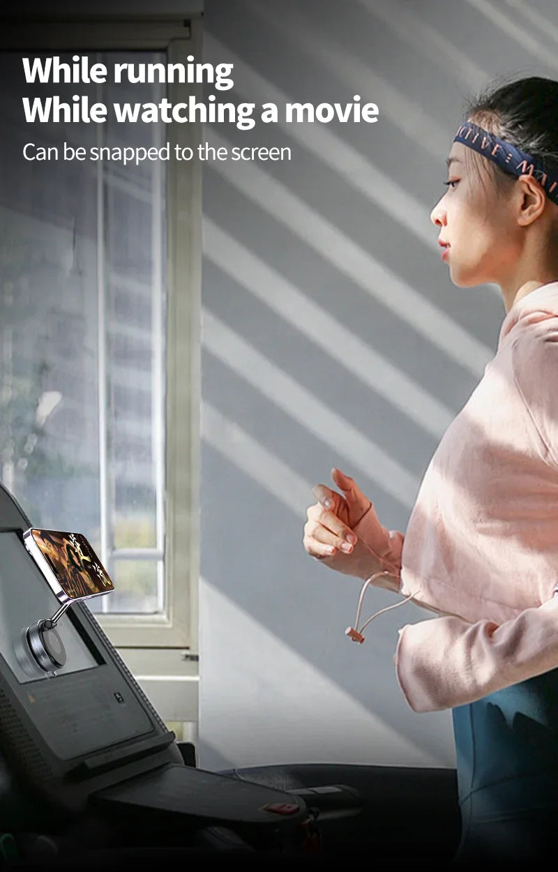 A silver magnetic phone mount attached to a treadmill screen, holding a smartphone while a woman runs.