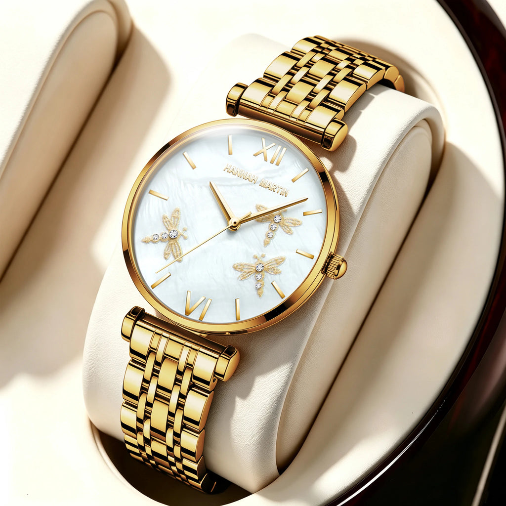 Gold Hannah Martin watch with round pearl dial, gold dragonfly reliefs, rhinestones, and link bracelet.